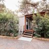 Casa mobile con veranda, circondata da alberi.