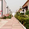 Sentiero tra bungalow fiancheggiato da fiori e arbusti.
