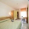Camera da letto con letto matrimoniale, scrivania e armadio aperto.
