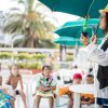 Persona mostra una piantina a un gruppo di bambini seduti all'aperto.