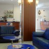 Salotto con divani blu e tavolini rotondi.