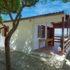 Una veranda di una casa bianca con tettoia in legno vista mare.