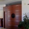 Reception con pareti in legno e piante decorative.