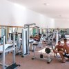 Una palestra con attrezzi per il sollevamento pesi e persone che si allenano.