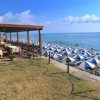 Spiaggia con ombrelloni blu e bianchi.