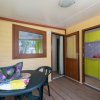 Veranda con tavolo nero e accesso cucina.