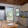 Cucina con tavolo da pranzo, frigo e porta aperta.