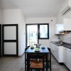 Cucina moderna con tavolo e sedie nere.