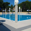 Piscina contornata da lettini e ombrelloni.