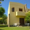 Casa gialla a due piani con balcone e giardino.