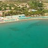 Acqua limpida e complesso turistico lungo la spiaggia.