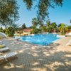 Piscina all'aperto con lettini e ombrelloni bianchi, circondata da palme.