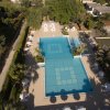Piscina a forma di L circondata da ombrelloni e piante.
