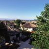 Complesso di bungalow con tetti di paglia, alberi e vista mare.