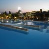 Piscina grande al tramonto con luci.