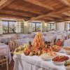 Sala da pranzo con buffet ricco e tavoli apparecchiati.