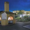 Forno esterno con camini accesi in un cortile illuminato di notte.