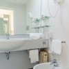 Un bagno moderno con lavabo, specchio grande e bidet.