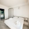 Camera da letto con letto matrimoniale, due comodini, armadio e bagno sullo sfondo.