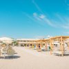 Spiaggia con lettini e ombrelloni sotto un cielo azzurro.