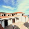 Edificio bianco con tetti rossi vicino a una spiaggia e mare.