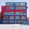 Edificio colorato a tre piani con balconi e insegna 