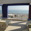Terrazza con lettini e vista sul mare, oltre un corrimano.