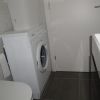 Bagno con lavatrice bianca e mobile con lavabo.