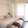 Camera da letto moderna con letto matrimoniale, biancheria a righe e asciugamani piegati.