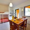 Cucina con tavolo quadrato e letti a castello.