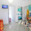 Soggiorno con divano a quadri arancione, cucina blu e tavolo con tovaglia decorata.
