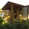 Veranda di legno di un bungalow con giardino verde intorno.