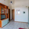 Sala luminosa con armadio TV e cucina vista.