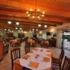 Ristorante con tavoli apparecchiati e soffitto con travi di legno.