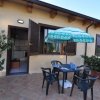Un patio esterno con tavolo, sedie, ombrellone e piante in vaso.