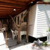 Mobile home con veranda coperta e sedie bianche.