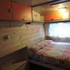 Camera da letto con pareti in legno, letto matrimoniale e mobili arancioni.