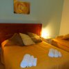 Camera con letto matrimoniale, lenzuola gialle, luci soffuse.