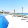 Piscina all'aperto con lettini, vista sul mare e cielo sereno.