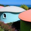 Case colorate a forma di fungo con vista sul mare.