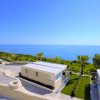 Due case moderne con tetti piatti, vista mare e giardino.