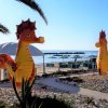 Due grandi cavallucci marini decorativi in un giardino di fronte alla spiaggia.