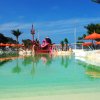 Piscina bassa con scenografie di pirati e ombrelloni arancioni sullo sfondo.