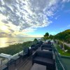 Terrazza con sedie, vista sul mare e cielo nuvoloso.