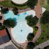 Vista dall'alto di una piscina a forma irregolare con sdraio tutt'intorno.
