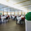 Ampia sala da pranzo con tavoli apparecchiati.
