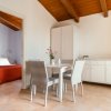 Sala da pranzo con tavolo e sedie di vimini, armadio bianco e vista su camera da letto.