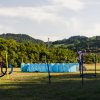 Un percorso di agility per cani all'aperto con ostacoli e un uomo in piedi con un cane.