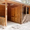 Casetta di legno con portico e finestre aperte.