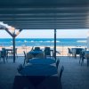 Una terrazza ristorante con vista sul mare e ombrelloni.